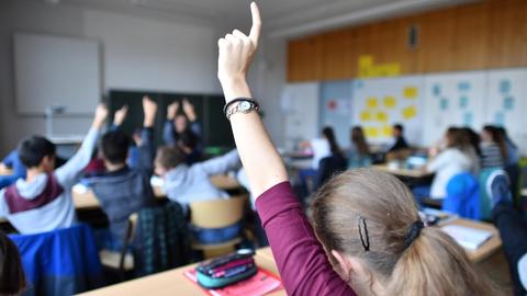 Siebtklässler strecken am 23.11.2016 während des Deutschunterrichts in einem Gymnasium in Friedrichshafen (Baden-Württemberg) ihre Hände nach oben.
