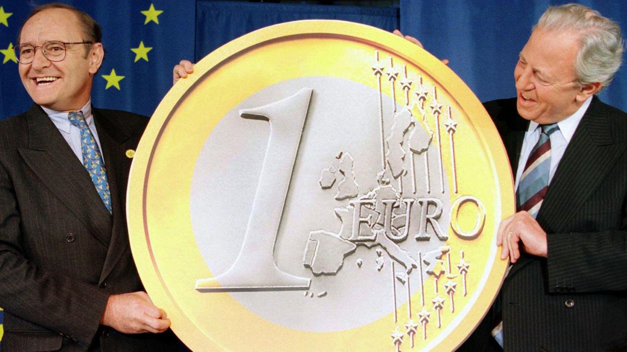 1998 präsentierten der damalige Präsident der EU-Kommission, Jacques Santer (r.) und der EU-Finanzkommissar Yves-Thibault de Silguy eine riesige Euro-Münze als Startschuss für die Europäische Währungsunion.