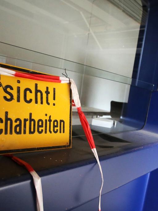 Ein Warnschild mit der Aufschrift "Vorsicht! Abbrucharbeiten" auf einer Baustelle in Wiesbaden.
