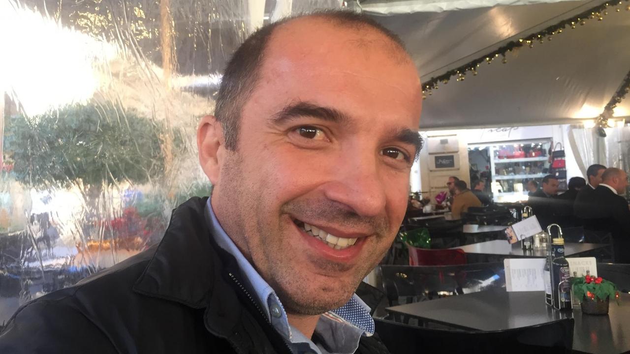 Kunsthistoriker Keith Sciberras trägt blaues Hemd und dunkle Jacke in einem Café. Kunsthistoriker Keith Sciberras trägt blaues Hemd und dunkle Jacke in einem Café.