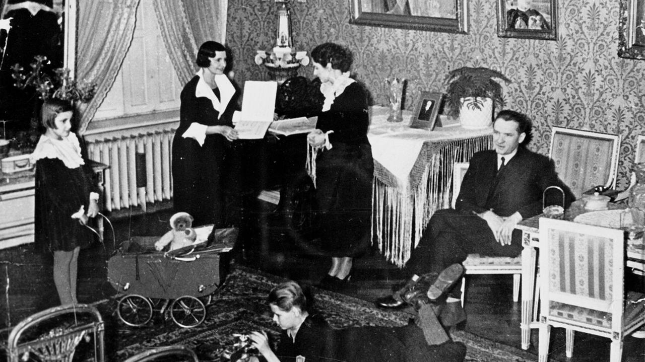 Aleksander Schiele mit seiner Frau Zofia (geb. Engemann) und den Kindern Jerzy und Julitta sowie der Gouvernante Irene im Salon ihrer Villa, 1930er Jahre.