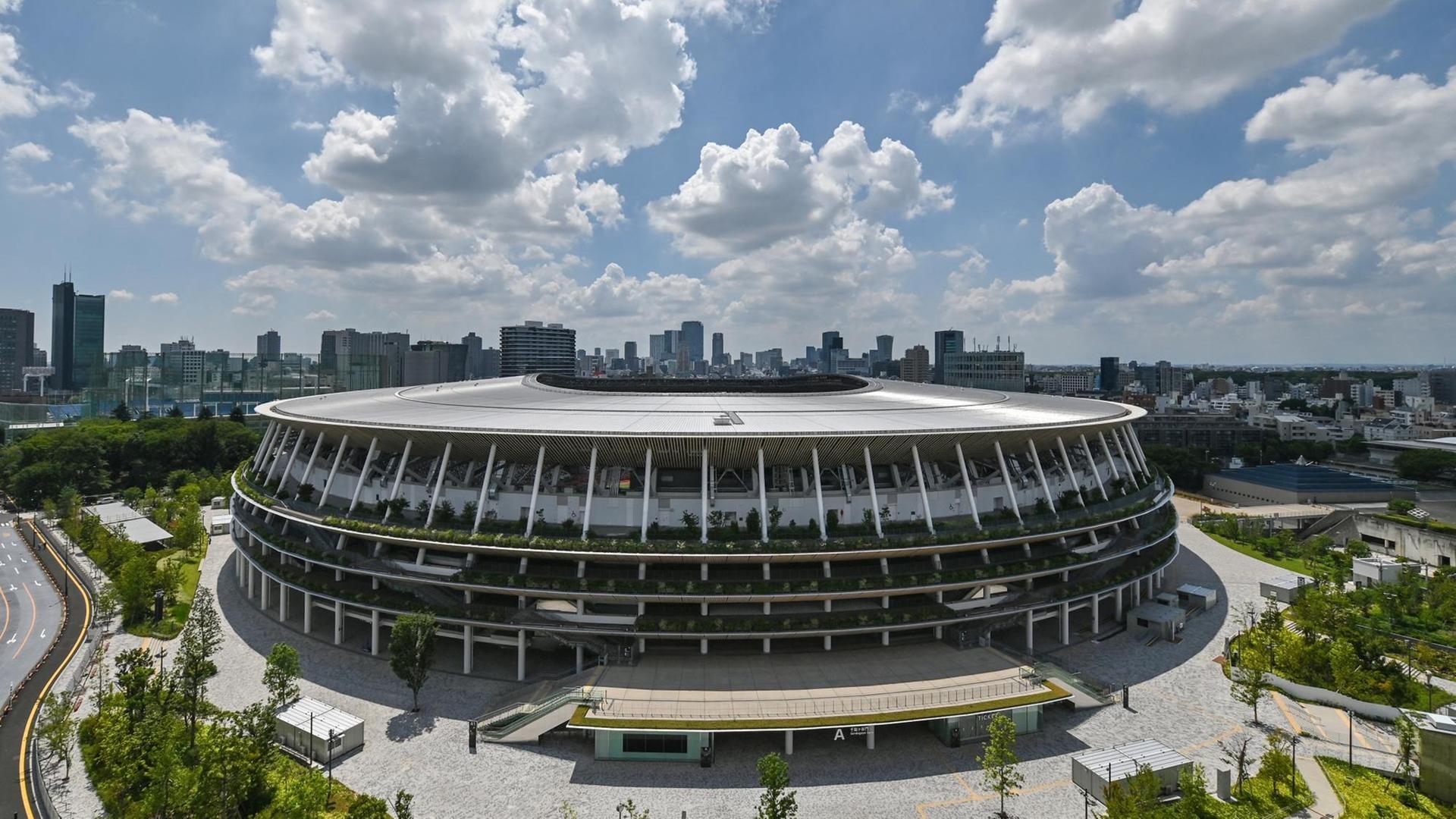 Fotografie des neu gebaute Japan National Stadiummit der Stadtsilhouette von Tokio im Hintergrund. Fotografie des neu gebaute Japan National Stadiummit der Stadtsilhouette von Tokio im Hintergrund.