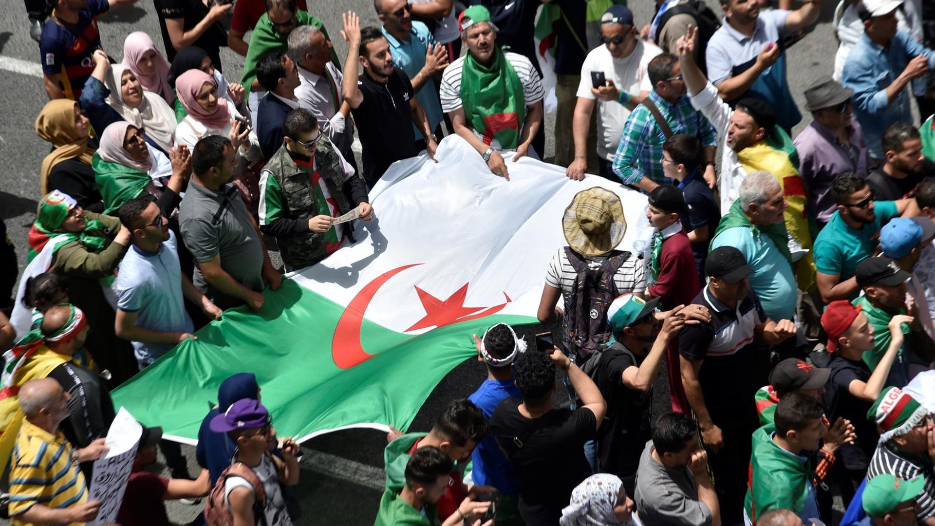 Algerische Demonstranten halten die Nationalflagge während ihrer Proteste in der Hauptstadt Algier Algerische Demonstranten halten die Nationalflagge während ihrer Proteste in der Hauptstadt Algier