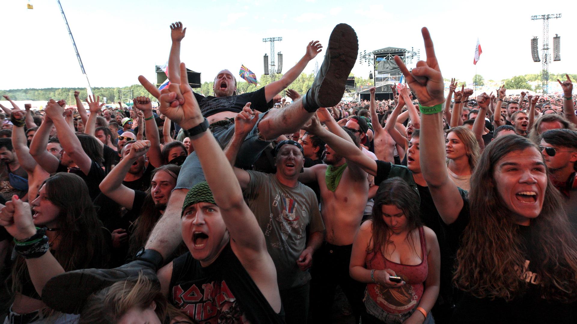 Besucher eines Konzertes beim Woodstock Bus Stop Festival in Kostryzyn on Odra in Polen recken die Hände zum Metal Sign geformt in die Höhe. Besucher eines Konzertes beim Woodstock Bus Stop Festival in Kostryzyn on Odra in Polen recken die Hände zum Metal Sign geformt in die Höhe.