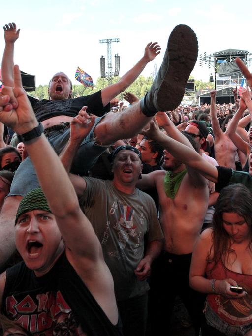 Besucher eines Konzertes beim Woodstock Bus Stop Festival in Kostryzyn on Odra in Polen recken die Hände zum Metal Sign geformt in die Höhe.