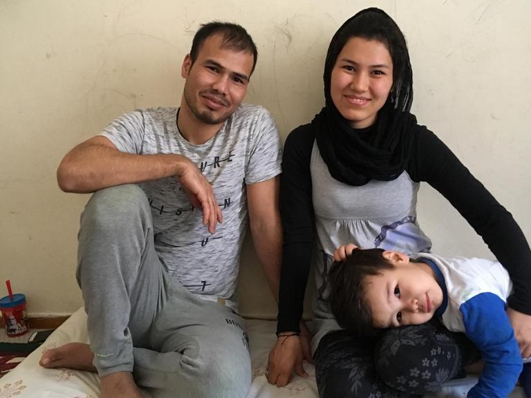 Reza, Soraya und Mohammad (v.l.n.r.) aus Afghanistan in ihrer vom UNHCR zur Verfügung gestellten Wohnung in Athen auf dem Boden sitzend. Mohammad´s Kopf liegt auf den Knien der Mutter.