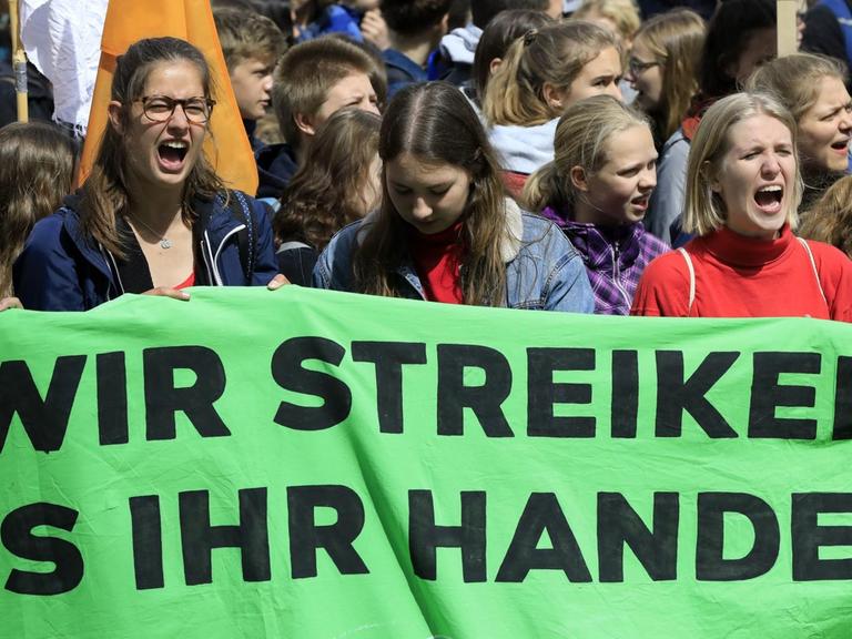 Schüler bei einer "Friday for Future"-Demonstration auf dem Operplatz in Hannover. Sie halten ein Plakat mit der Aufschrift "Wir streiken, bis ihr handelt" hoch.