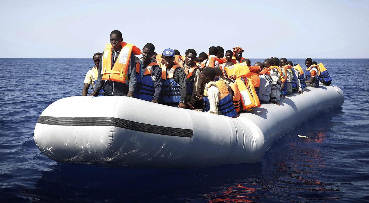 Ein Boot mit Dutzenden Flüchtlingen aus Afrika auf offener See. Ein Boot mit Dutzenden Flüchtlingen aus Afrika auf offener See.