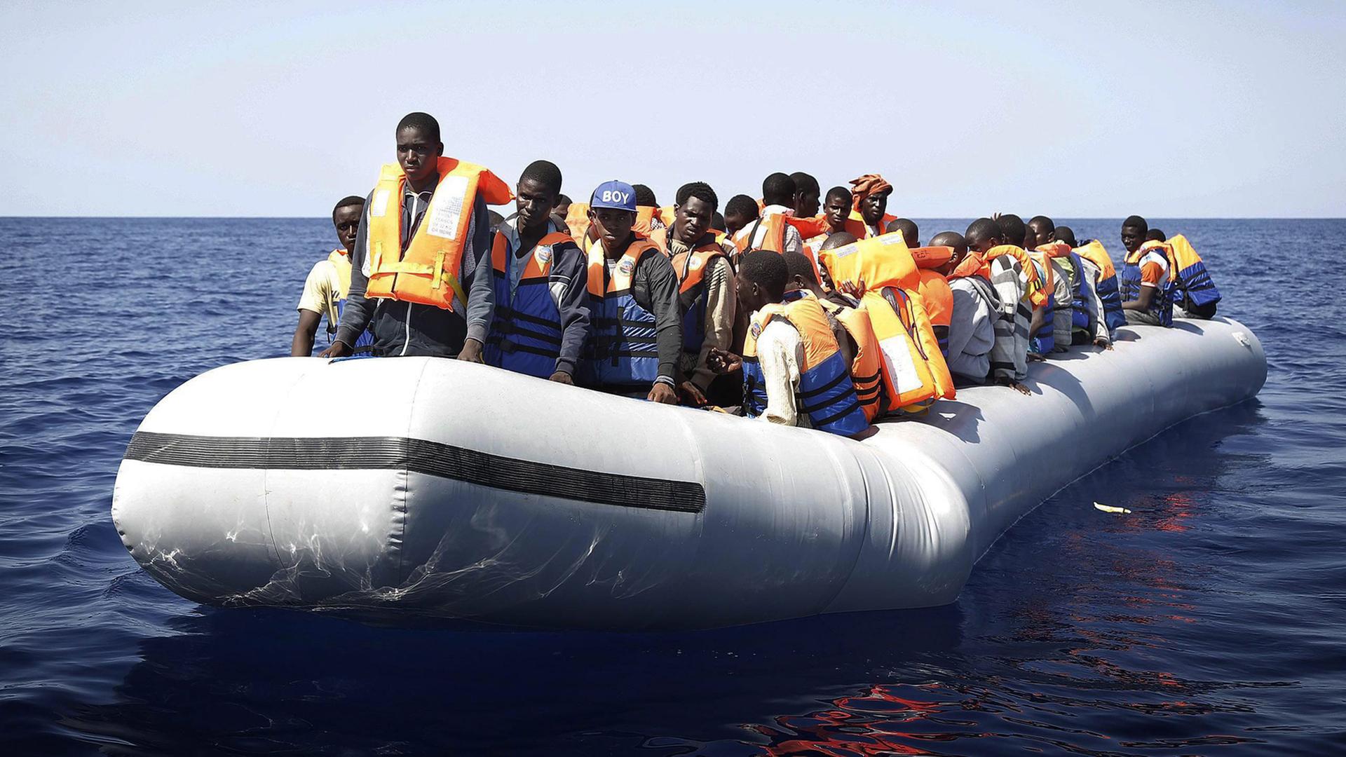 Ein Boot mit Dutzenden Flüchtlingen aus Afrika auf offener See. Ein Boot mit Dutzenden Flüchtlingen aus Afrika auf offener See.