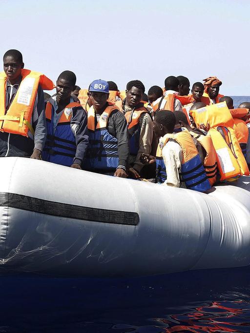 Ein Boot mit Dutzenden Flüchtlingen aus Afrika auf offener See. 