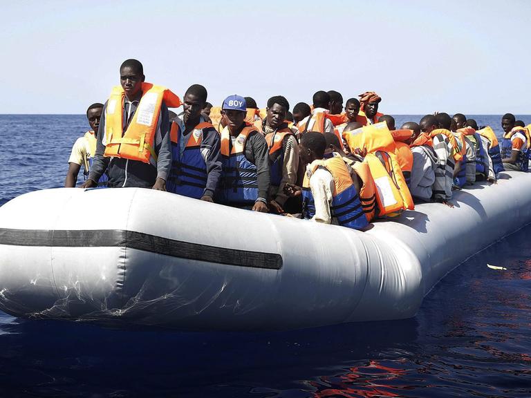 Ein Boot mit Dutzenden Flüchtlingen aus Afrika auf offener See. 