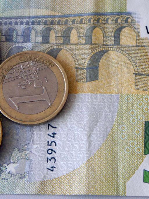 Ein Fünf-Euro-Schein liegt mit einem Ein- und Zwei-Euro und einem 50-Cent-Stück auf einem Stapel.