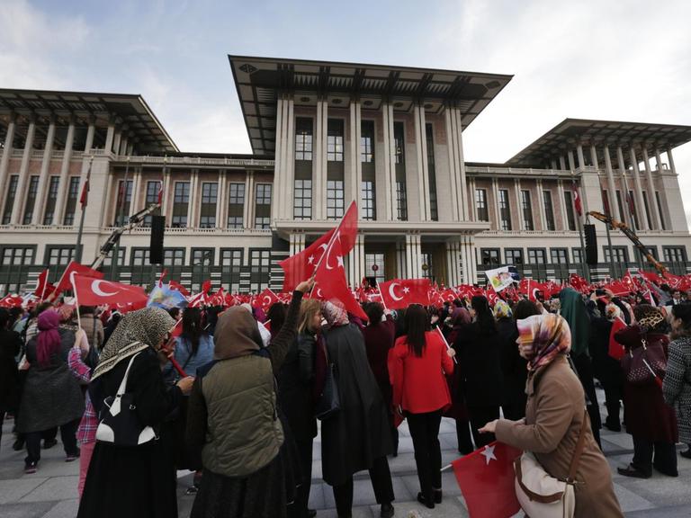 Anhänger des türkischen Staatspräsidenten Erdogan stehen am 17.04.2017 mit Flaggen vor dem Präsidentenpalast in Ankara (Türkei).