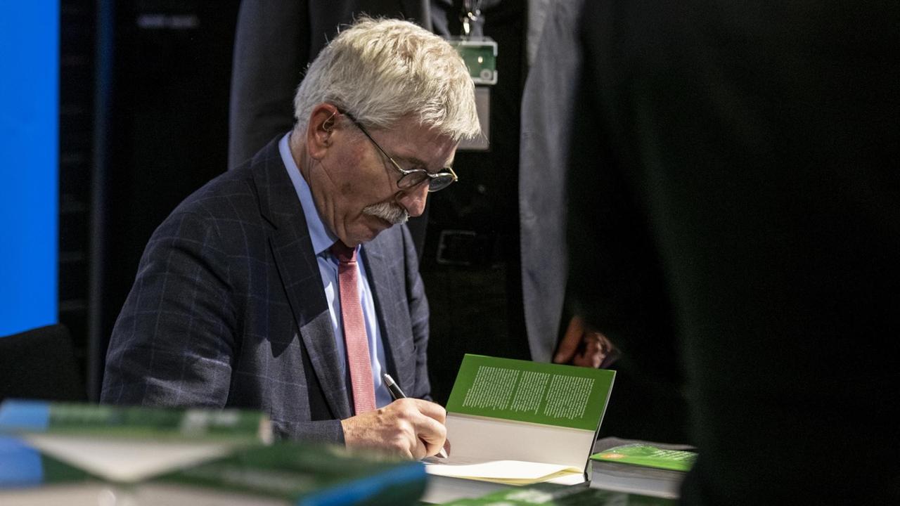 Thilo Sarrazin, Autor und ehemaliger SPD-Politiker, signiert sein neues Buch "Feindliche Uebernahme", am Weltwoche-Event "Gipfeltreffen der freien Rede" in der Samsung Hall, am Donnerstag, 4. Oktober 2018, in Zuerich. Thilo Sarrazin hat mit "Deutschland schafft sich ab" einen umstrittenen Bestseller ueber den Islam und Europa geschrieben. (KEYSTONE/Patrick Huerlimann) | Thilo Sarrazin, Autor und ehemaliger SPD-Politiker, signiert sein neues Buch "Feindliche Uebernahme", am Weltwoche-Event "Gipfeltreffen der freien Rede" in der Samsung Hall, am Donnerstag, 4. Oktober 2018, in Zuerich. Thilo Sarrazin hat mit "Deutschland schafft sich ab" einen umstrittenen Bestseller ueber den Islam und Europa geschrieben. (KEYSTONE/Patrick Huerlimann) |
