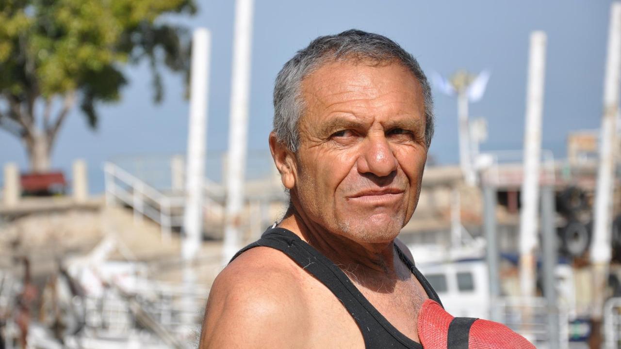Menachem Lev aus dem Kibbuz Ein Gev ist Fischer auf dem See Genezareth. Er steht in der Sonne und blickt auf das Wasser.
