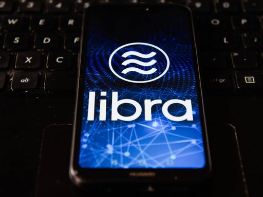 Auf dem Display eines Smartphone ist das Libra-Logo zu sehen.