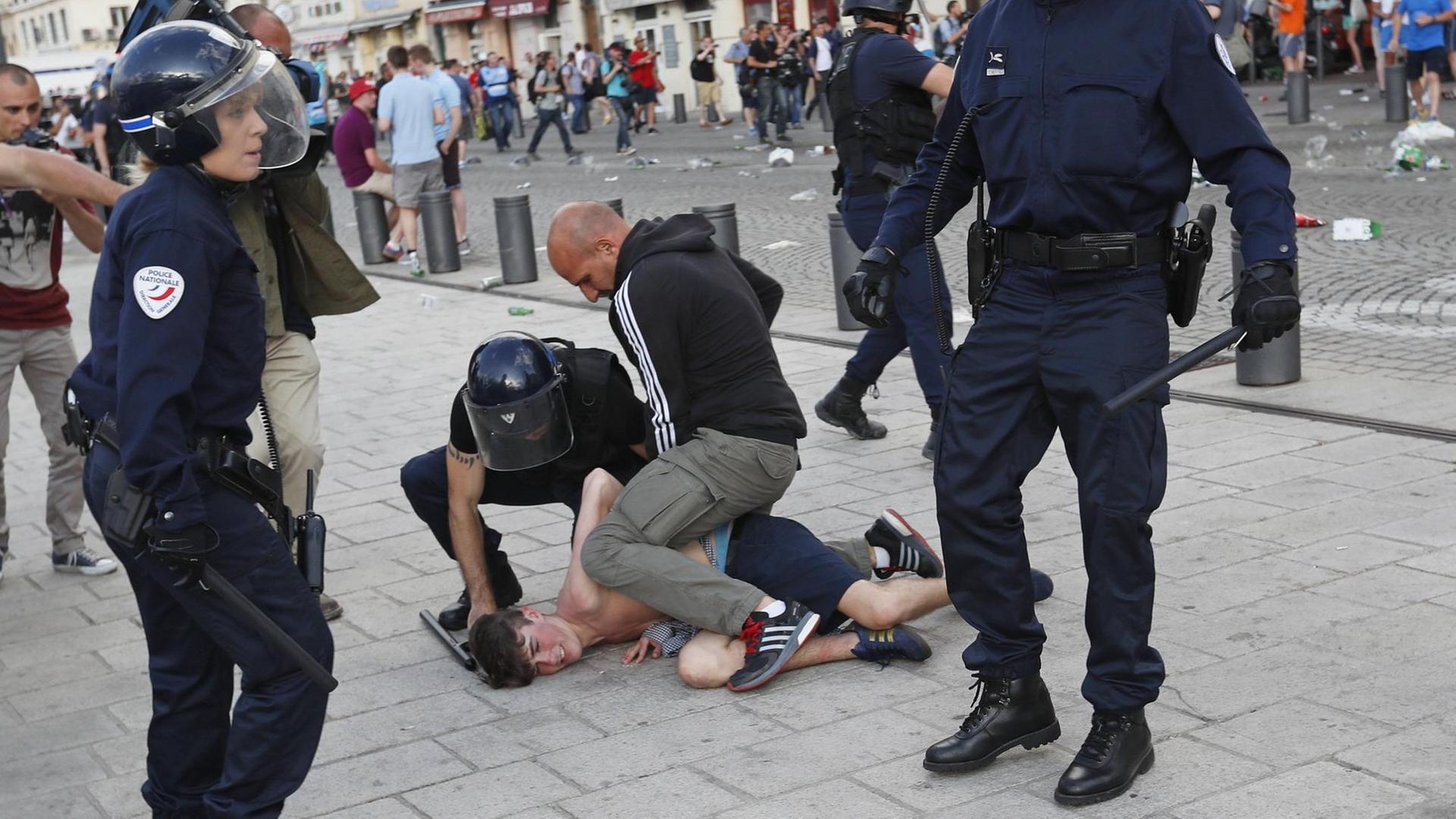 Ein Mann wird von französischen Sicherheitskräften in Marseille festgehalten.