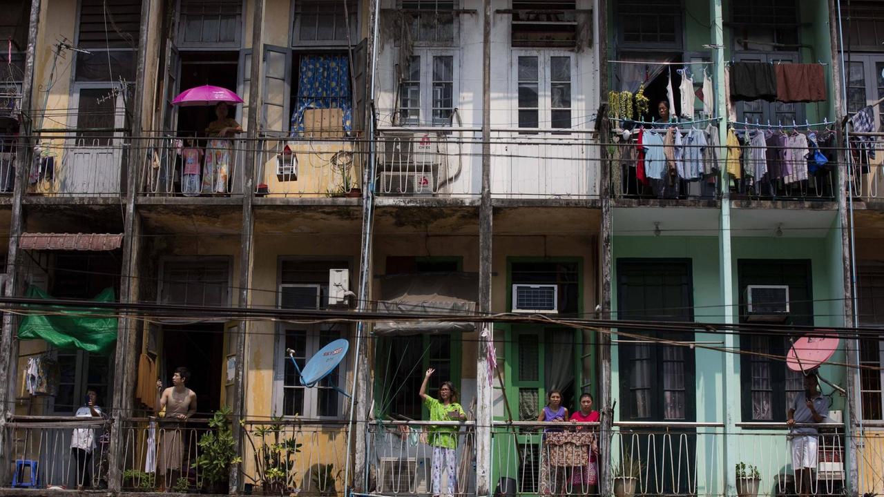 Bewohner eines Wohnblocks in Yangon stehen auf ihren Balkons und schauen auf die Straße. Bewohner eines Wohnblocks in Yangon stehen auf ihren Balkons und schauen auf die Straße.