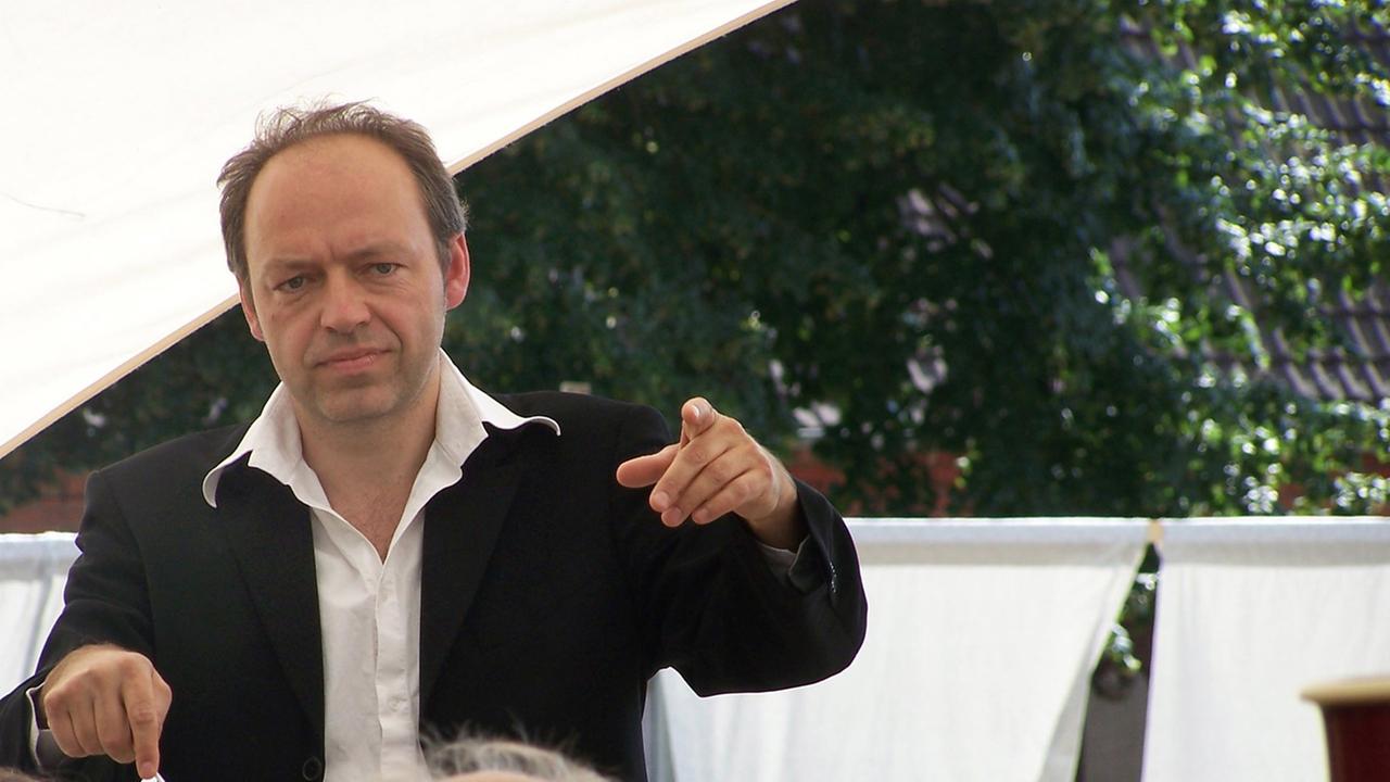 Steffen Tast (l) dirigiert bei "Dorf macht Oper" in seinem Heimatort Klein Leppin in der Prignitz die Kollegen vom Berliner Rundfunk-Sinfonieorchester.