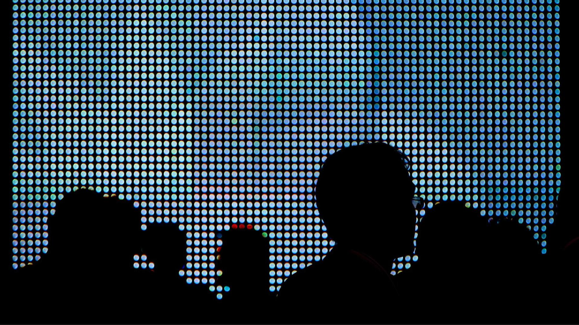 Die Schattenrisse von Messepublikum erscheinen vor den grell-blauen Leuchtdioden eines großen LED-Displays. Aufgenommen auf der Sicherheitsmesse Infosec in London am 28.04.2010. Foto: Maximilian Schönherr | Verwendung weltweit Die Schattenrisse von Messepublikum erscheinen vor den grell-blauen Leuchtdioden eines großen LED-Displays. Aufgenommen auf der Sicherheitsmesse Infosec in London am 28.04.2010. Foto: Maximilian Schönherr | Verwendung weltweit