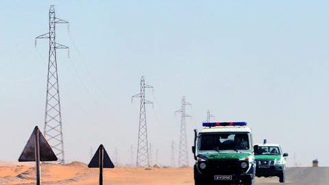 Algerische Sicherheitskräfte fahren mit zwei Autos durch die Wüste.
