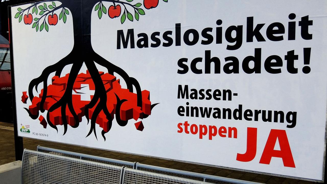 Das Plakat zeigt einen schwarzen Apfelbaum, dessen Wurzeln das Land Schweiz erdrücken. Daneben steht "Masslosigkeit schadet! Masseneinwanderung stoppen Ja" Das Plakat zeigt einen schwarzen Apfelbaum, dessen Wurzeln das Land Schweiz erdrücken. Daneben steht "Masslosigkeit schadet! Masseneinwanderung stoppen Ja"