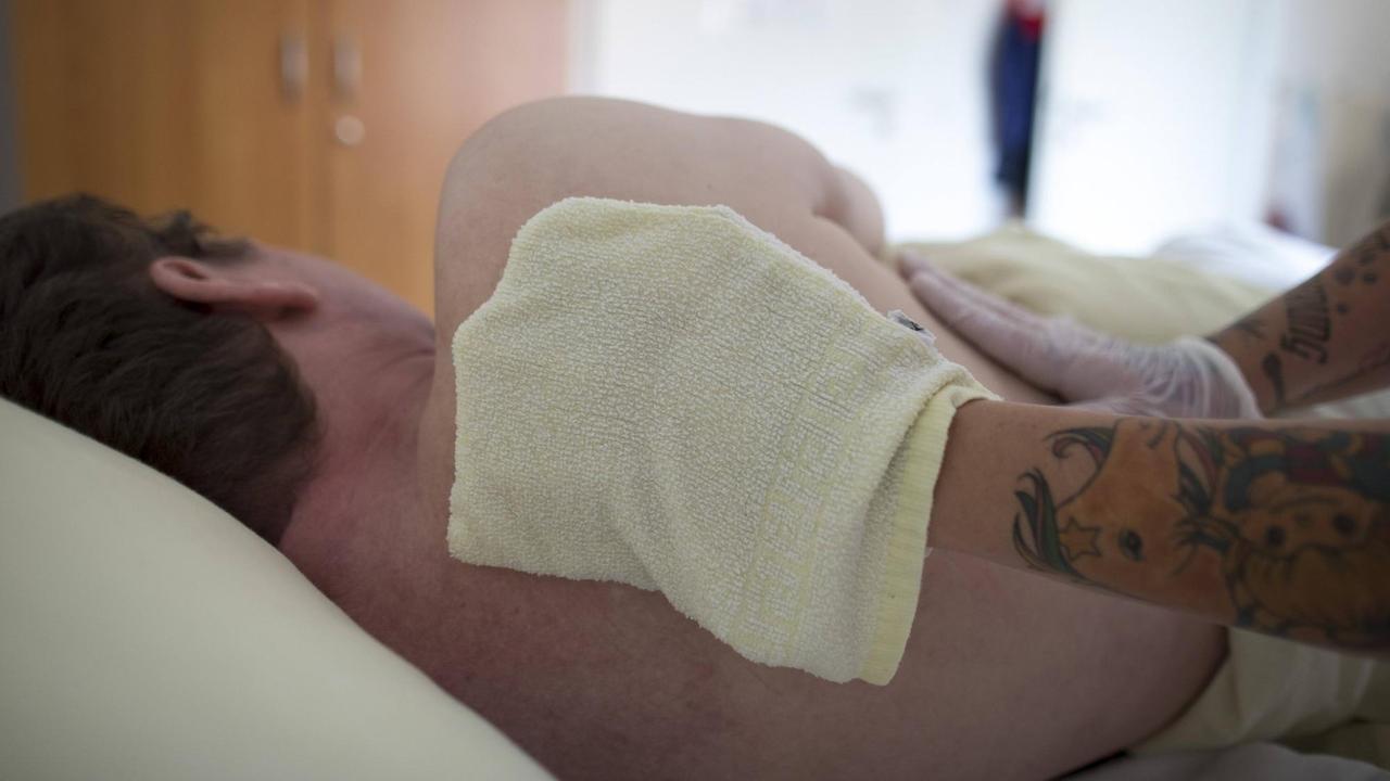 Eine Altenpflegerin wäscht einem Bewohner in einem Altenpflegeheim den Ruecken. Eine Altenpflegerin wäscht einem Bewohner in einem Altenpflegeheim den Ruecken.