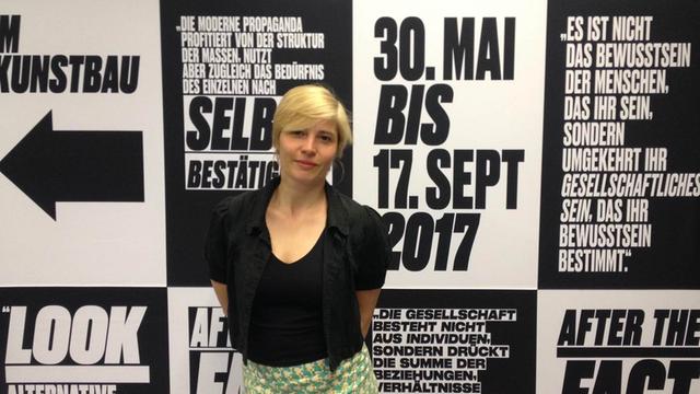 Kuratorin Stephanie Weber vor Plakaten zur Ausstellung "After the Fact. Propaganda im 21. Jahrhundert" (Bild: Andi Hörmann)