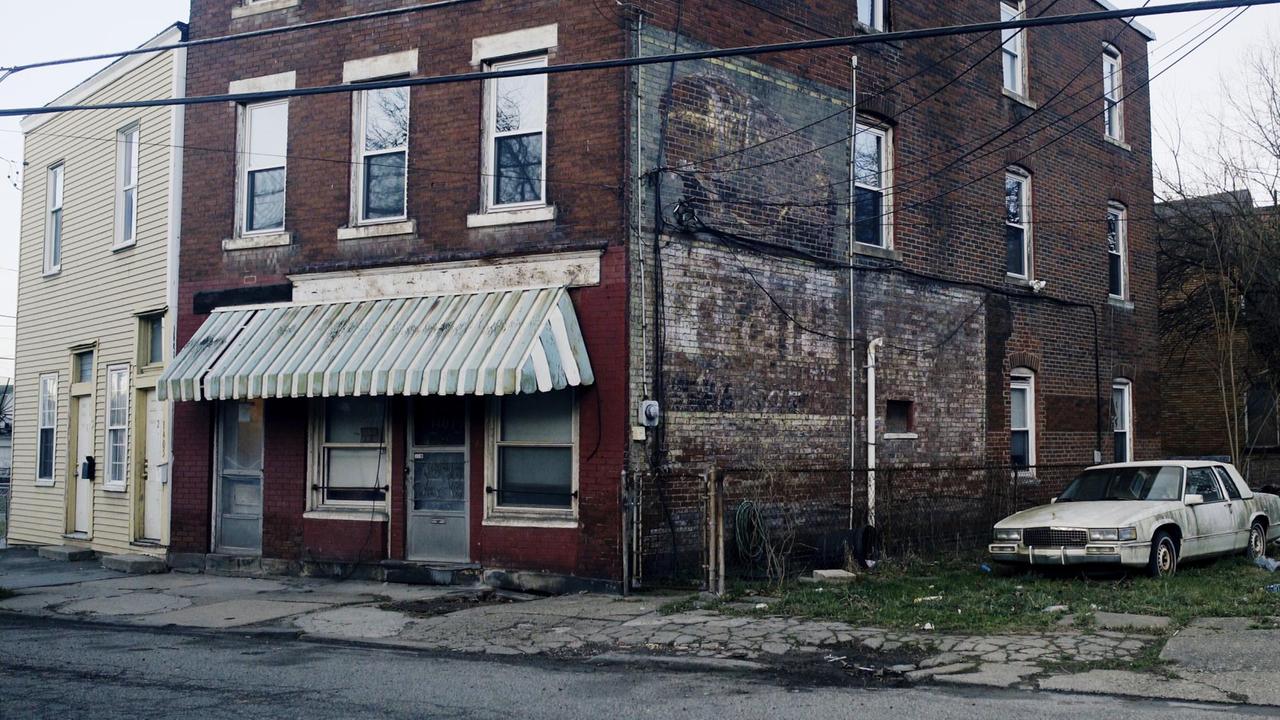 Ein runtergekommenes Backsteinhaus in Pittsburgh. Daneben steht ein Autowrack. Ein runtergekommenes Backsteinhaus in Pittsburgh. Daneben steht ein Autowrack.