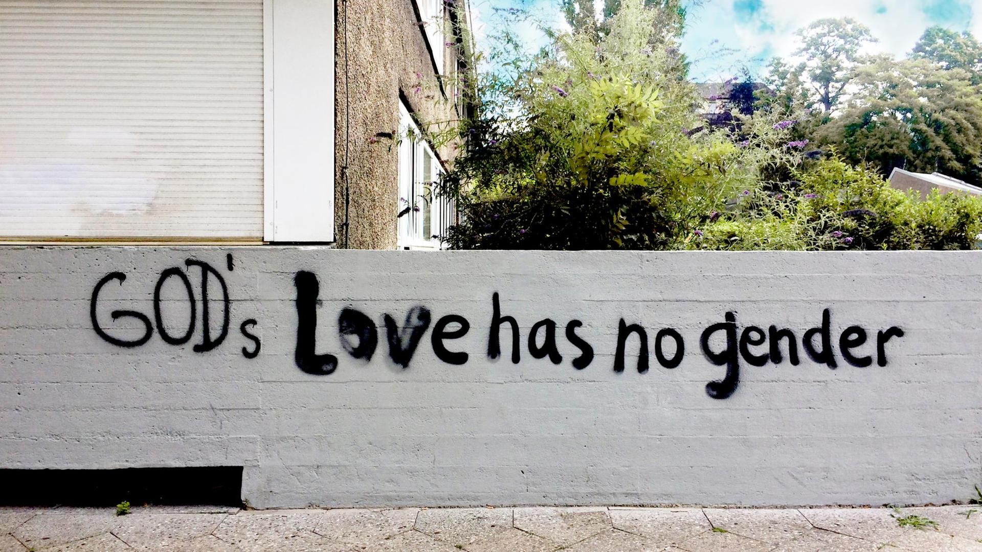 Auf einer Hauswand sind die Worte "God’s Love has no gender" gesprüht. Auf einer Hauswand sind die Worte "God’s Love has no gender" gesprüht.