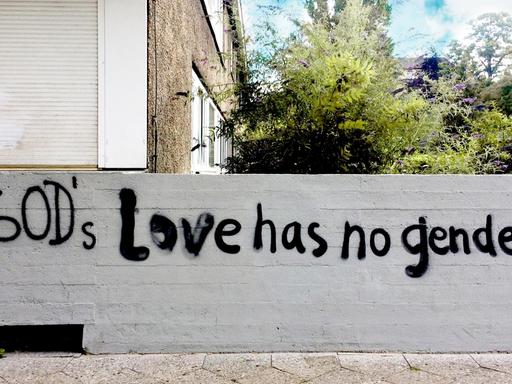 Auf einer Hauswand sind die Worte "God’s Love has no gender" gesprüht.