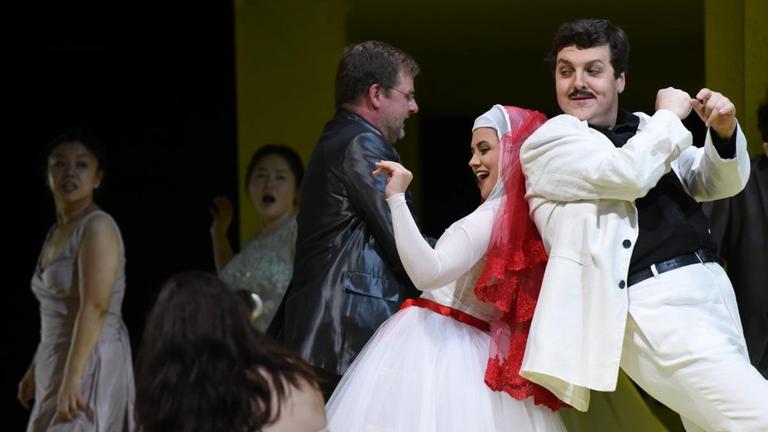 Das tanzende Hochzeitspaar Zerlina und Masetto inmitten von fröhlichen Gästen, fotografiert auf der Bühne vom Staatstheater Wiesbaden 2018.