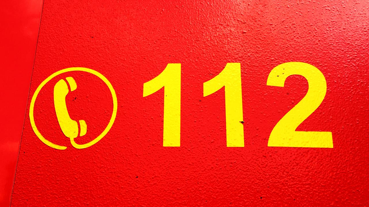 Das Zeichen eines Telefonhörers und die Nummern 112 stehen in knallgelf auf einem roten Untergrund.