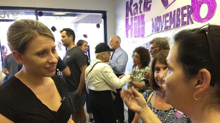 Katie Hill spricht mit einer Wahlkampfhelferin. Im Hintergrund unterhalten sich viele Leute. Katie Hill spricht mit einer Wahlkampfhelferin. Im Hintergrund unterhalten sich viele Leute.