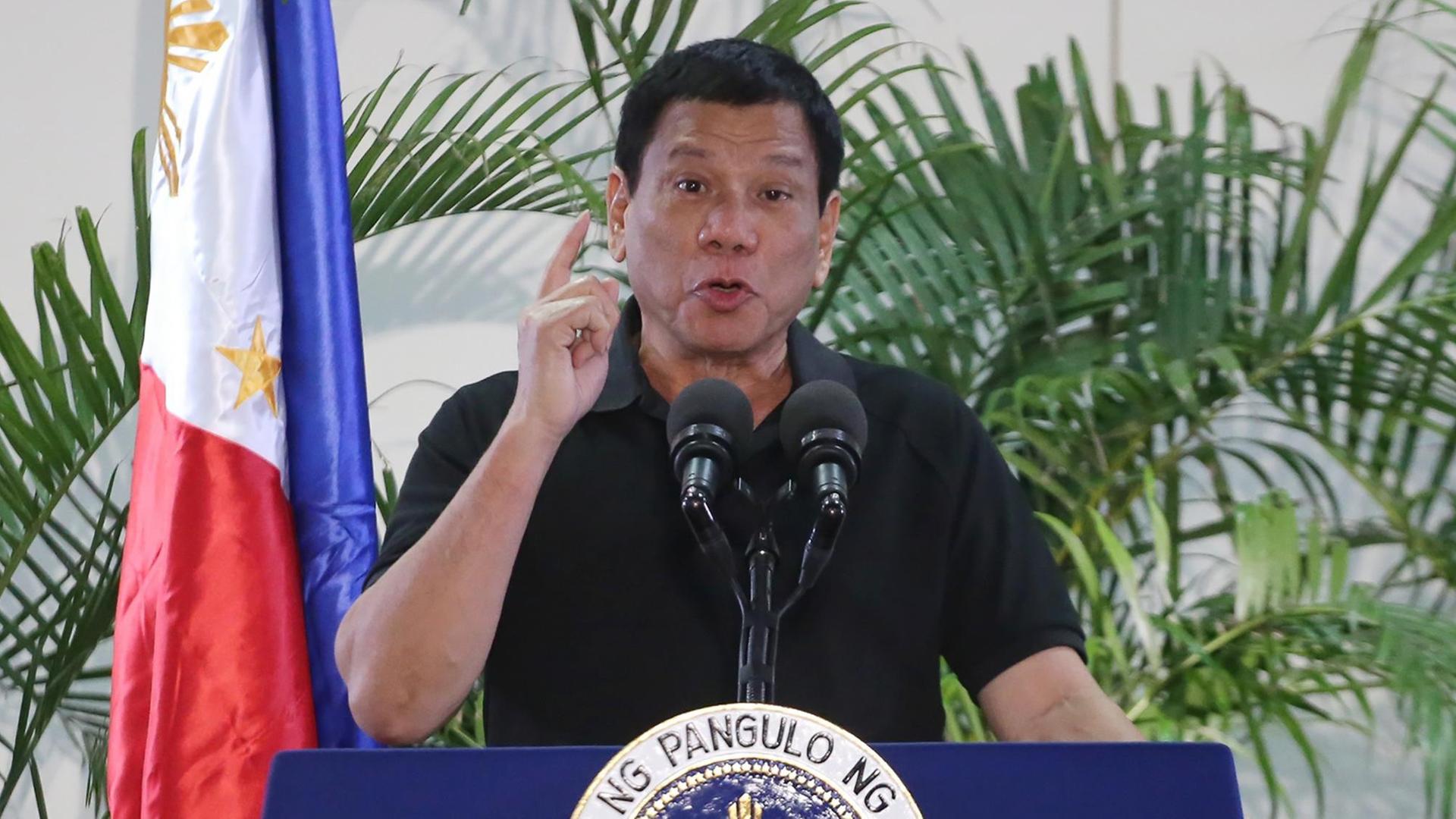 Duterte steht neben einer Flagge und hält eine Rede. Duterte steht neben einer Flagge und hält eine Rede.
