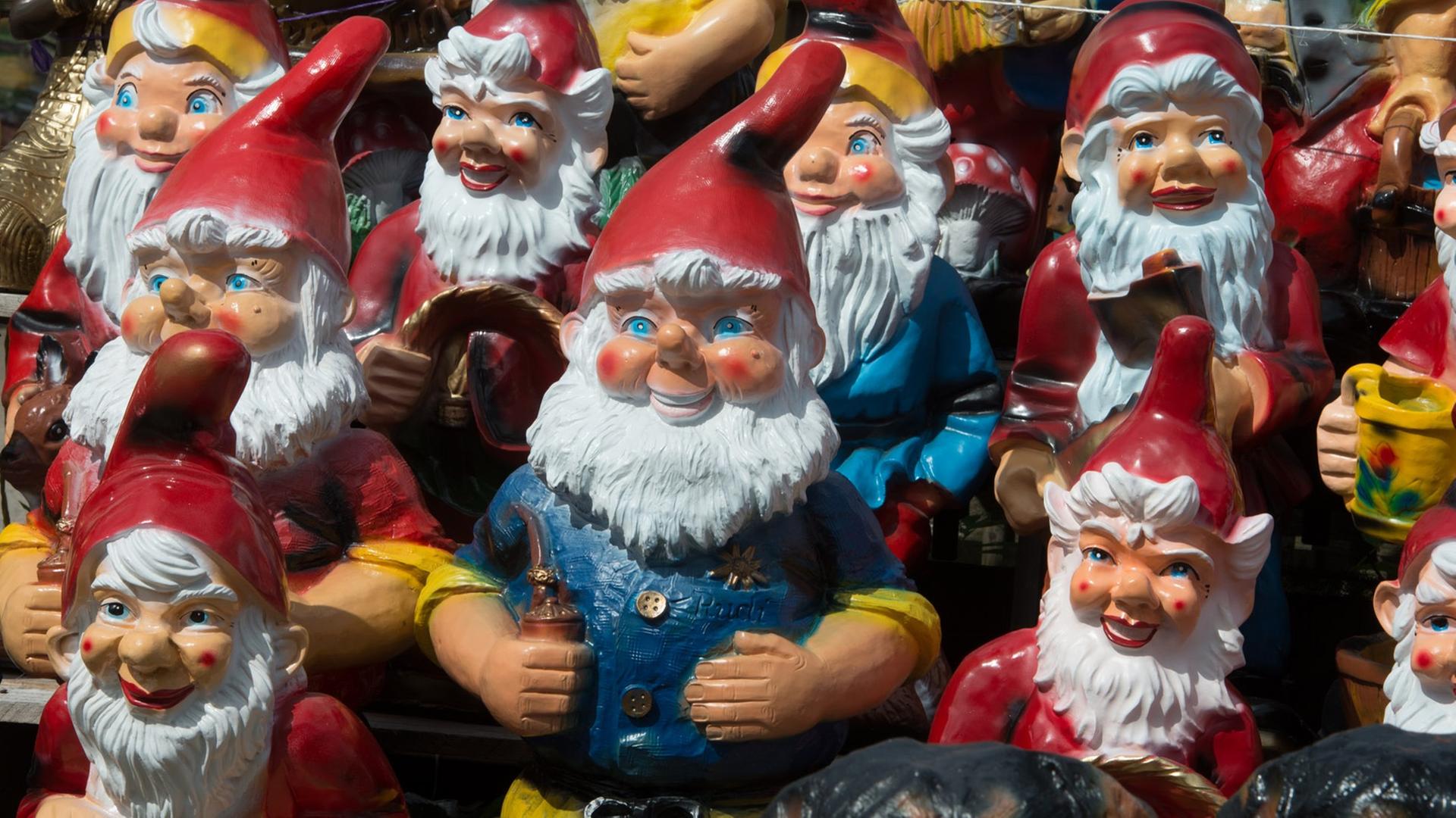 Viele bunte Gartenzwerge aus Plastik stehen dicht beieinander. Viele bunte Gartenzwerge aus Plastik stehen dicht beieinander.