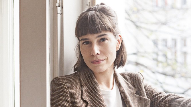 Foto von Esther Becker. Sie lehnt an einem Fenster. Foto von Esther Becker. Sie lehnt an einem Fenster.
