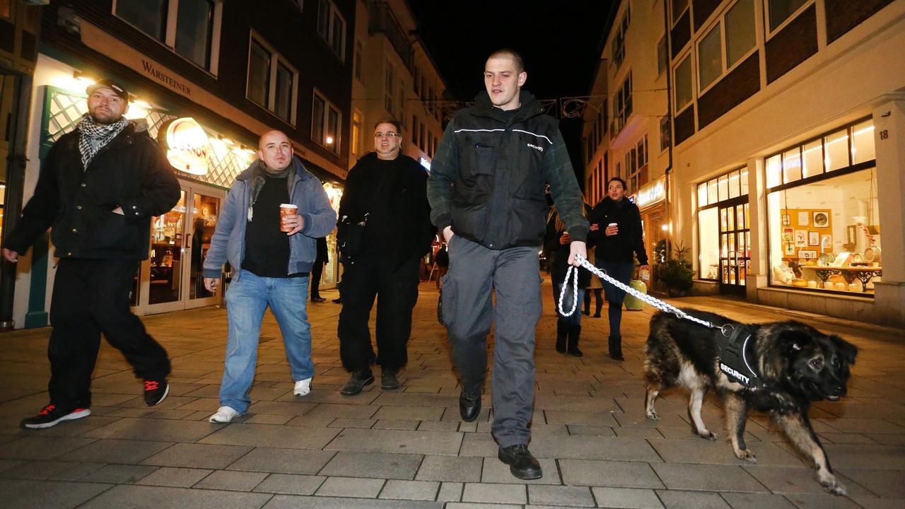 Sympathisanten einer Düsseldorfer Bürgerwehr ziehen im Dunkeln mit einem Hund durch die Altstadt. Sympathisanten einer Düsseldorfer Bürgerwehr ziehen im Dunkeln mit einem Hund durch die Altstadt.