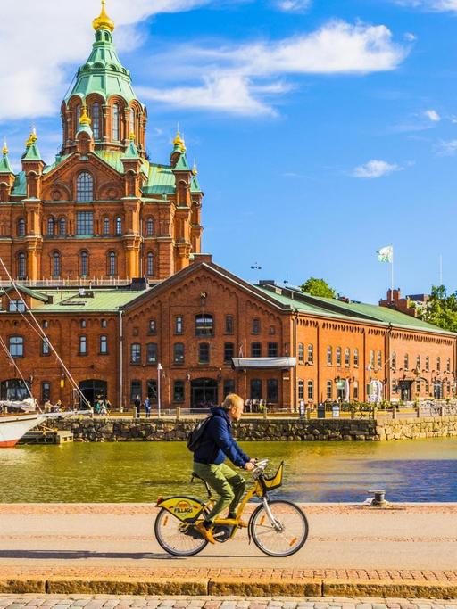 Ein Fahrradfaher vor der Uspenski-Kathedrale in der finnischen Hauptstadt Helsinki.