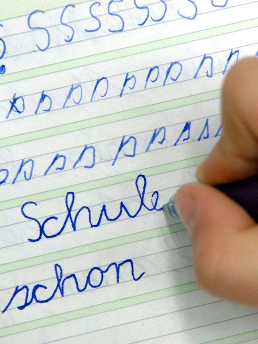 In der Dorfschule in Görzig nahe Beeskow schreibt ein Mädchen im Unterricht das Wort "Schule" in ihr Heft.