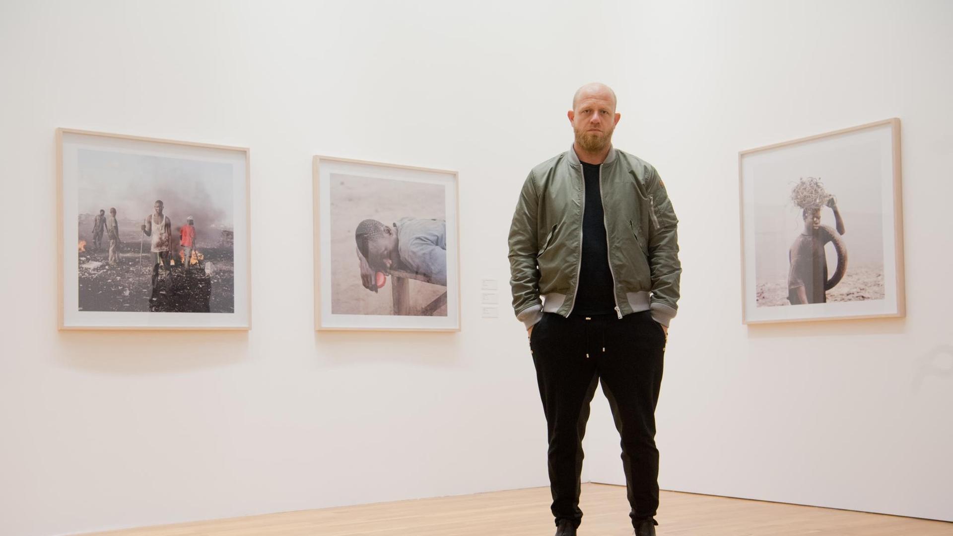 Der südafrikanische Fotokünstler Pieter Hugo steht am 16.02.2017 vor Fotos aus Ghana in der Fotografieausstellung "Between the devil and the deep blue sea" im Kunstmuseum Wolfsburg. Es ist die erste institutionelle Einzelausstellung des Fotografen in Deutschland. Hugo beschäftigt sich mit Formen des Zusammenlebens unterschiedlicher Menschen in Diktaturen. Der südafrikanische Fotokünstler Pieter Hugo steht am 16.02.2017 vor Fotos aus Ghana in der Fotografieausstellung "Between the devil and the deep blue sea" im Kunstmuseum Wolfsburg. Es ist die erste institutionelle Einzelausstellung des Fotografen in Deutschland. Hugo beschäftigt sich mit Formen des Zusammenlebens unterschiedlicher Menschen in Diktaturen.