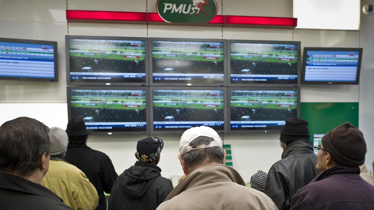 Spieler verfolgen ein Pferderennen in einem Wettbüro des französischen Anbieters PMU in Lyon Spieler verfolgen ein Pferderennen in einem Wettbüro des französischen Anbieters PMU in Lyon