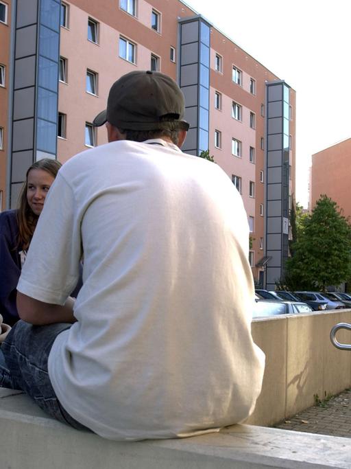 Berlin: Jugendliche sitzen auf einer Mauer in der Plattenbausiedlung Hellersdorf.