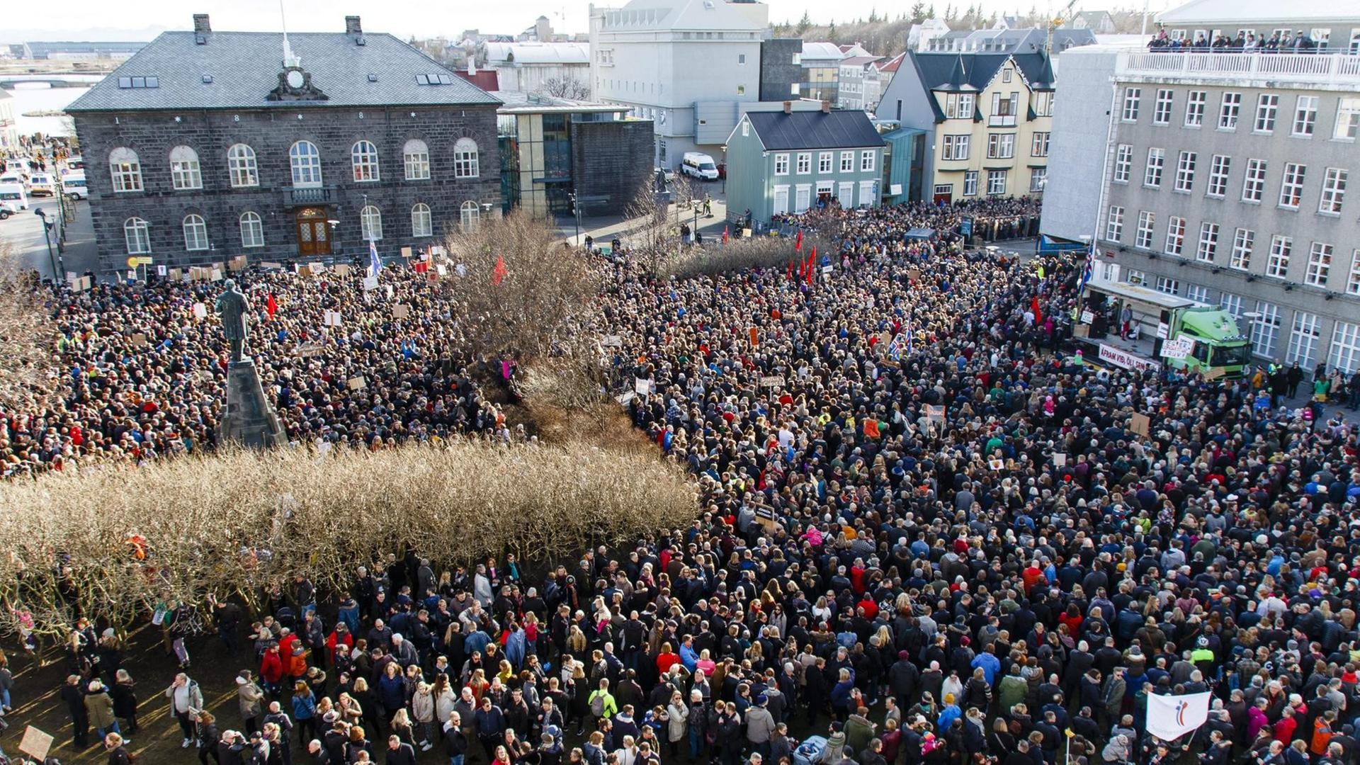 Sie sehen eine große Menschenmenge vor dem Parlament in Reykjavík. Sie sehen eine große Menschenmenge vor dem Parlament in Reykjavík.