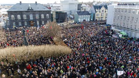 Sie sehen eine große Menschenmenge vor dem Parlament in Reykjavík.