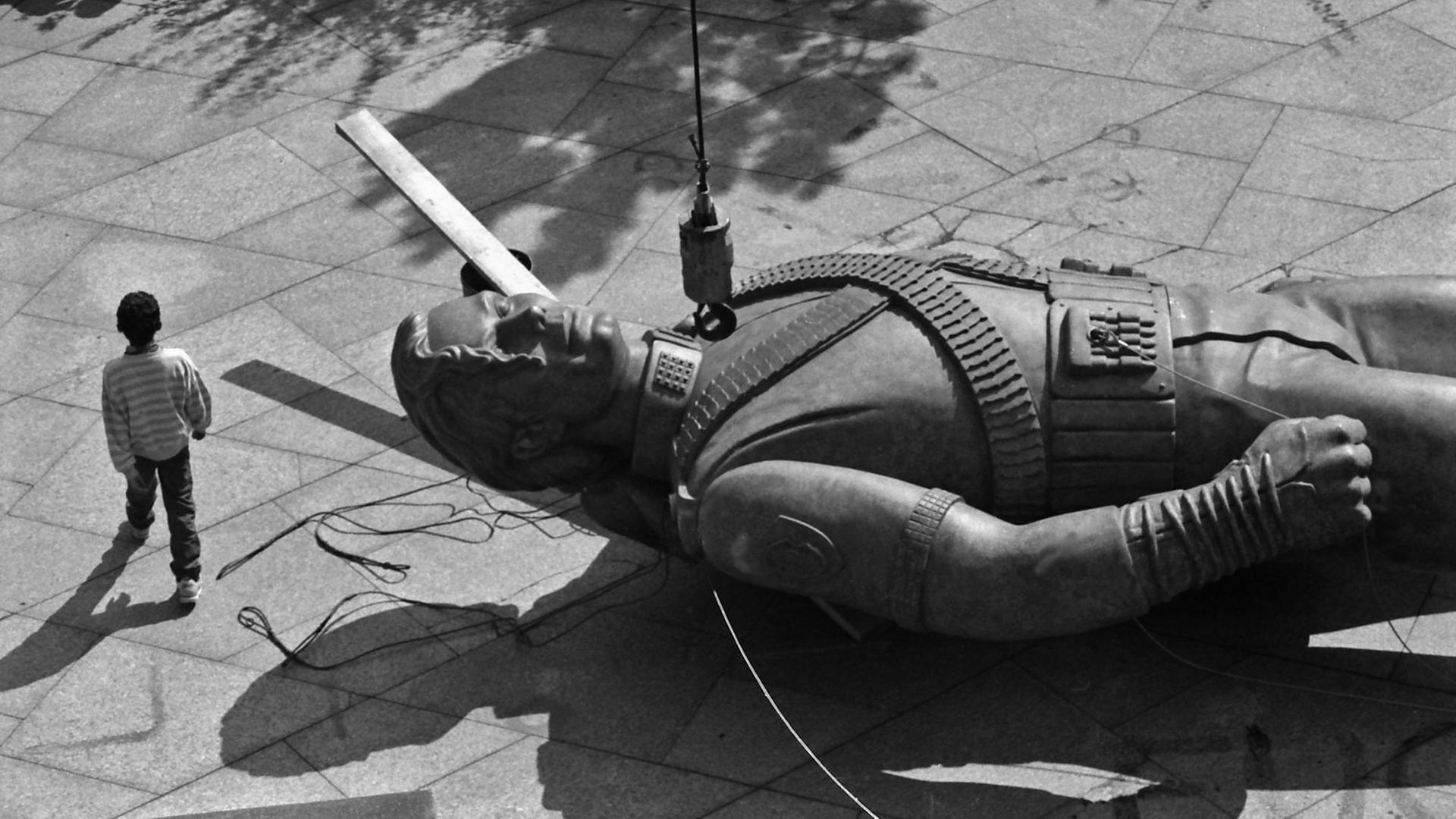 Eine Michael-Jackson-Statue in Überlebensgröße liegt auf einem Steinboden, ein Junge läuft daran vorbei. (Foto von 1996 aus Prag) Eine Michael-Jackson-Statue in Überlebensgröße liegt auf einem Steinboden, ein Junge läuft daran vorbei. (Foto von 1996 aus Prag)