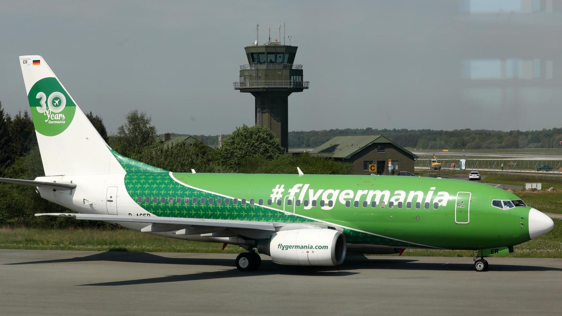 Ein grünes Flugzeug mit der Aufschrift #flygermania am Flughafen Rostock-Laage Ein grünes Flugzeug mit der Aufschrift #flygermania am Flughafen Rostock-Laage