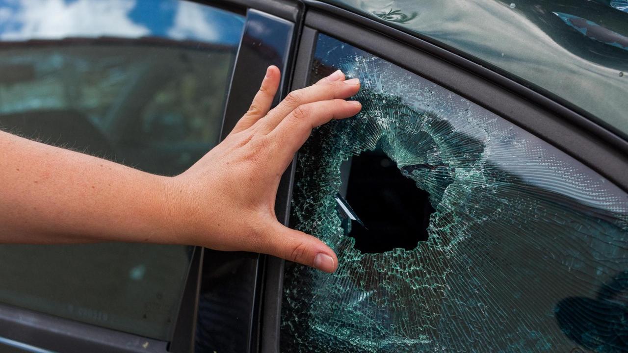 Ein Anwohner zeigt den Schaden an einem Autofenster, den ein Hagelsturm hinterlassen hat. Ein Anwohner zeigt den Schaden an einem Autofenster, den ein Hagelsturm hinterlassen hat.