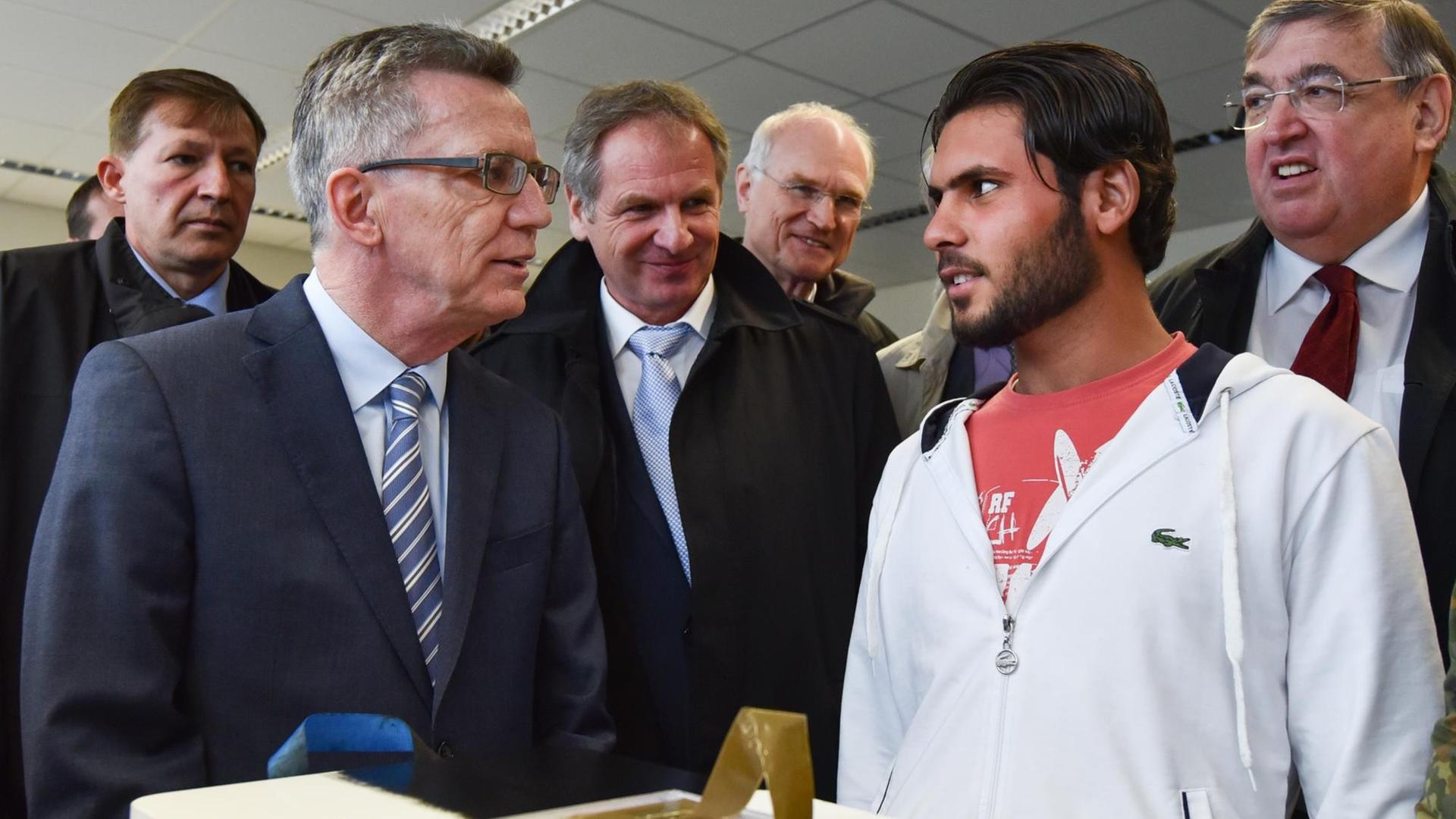 Thomas de Maizière und andere Politiker bei einem Besuch in einem Flüchtlings-Zentrum