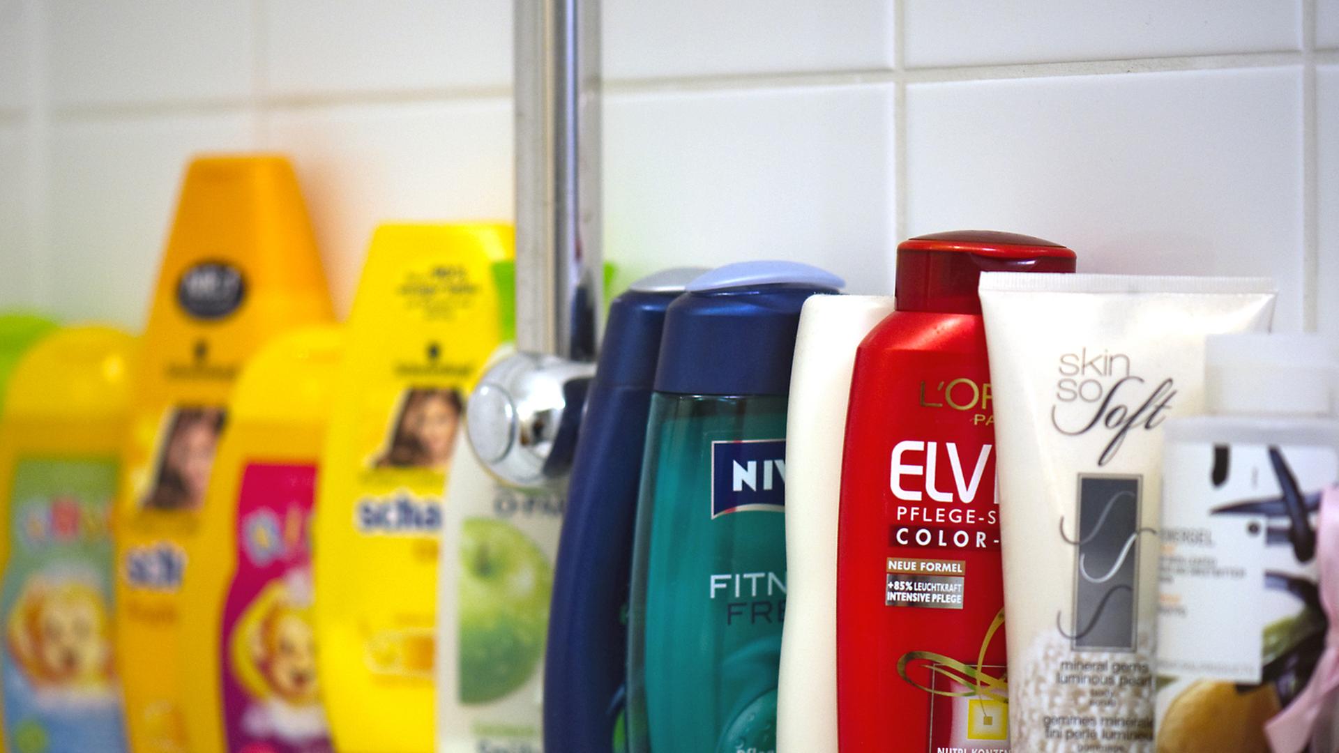 Körperpflege-Produkte stehen in einer Reihe auf einem Badewannenrand Körperpflege-Produkte stehen in einer Reihe auf einem Badewannenrand